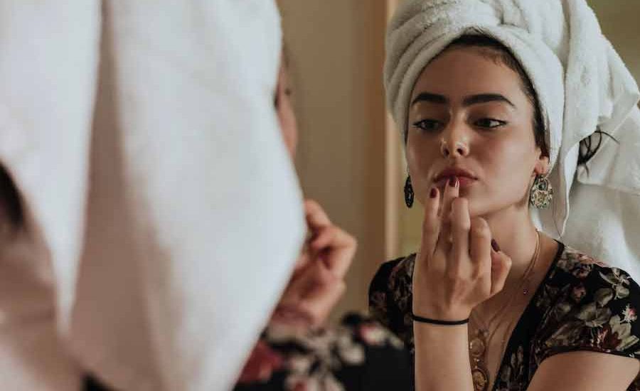 Kenali Bahan Dasar Produk Kecantikan ini, Agar tak Menyesal Kemudian Seorang perempuan sedang mematut diri di depan cermin (foto: Kevin Laminto | unsplash)